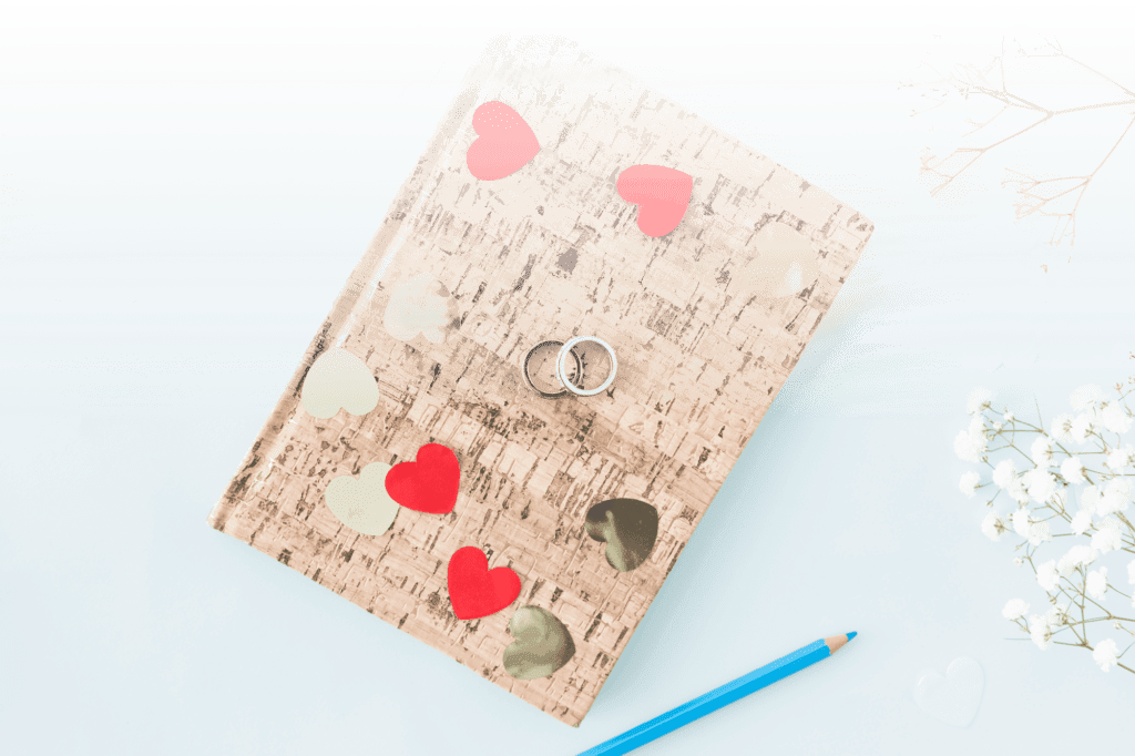 Creative wedding guest book with heart decorations, pencil, and rings—perfect for collecting wedding photos with a QR code.